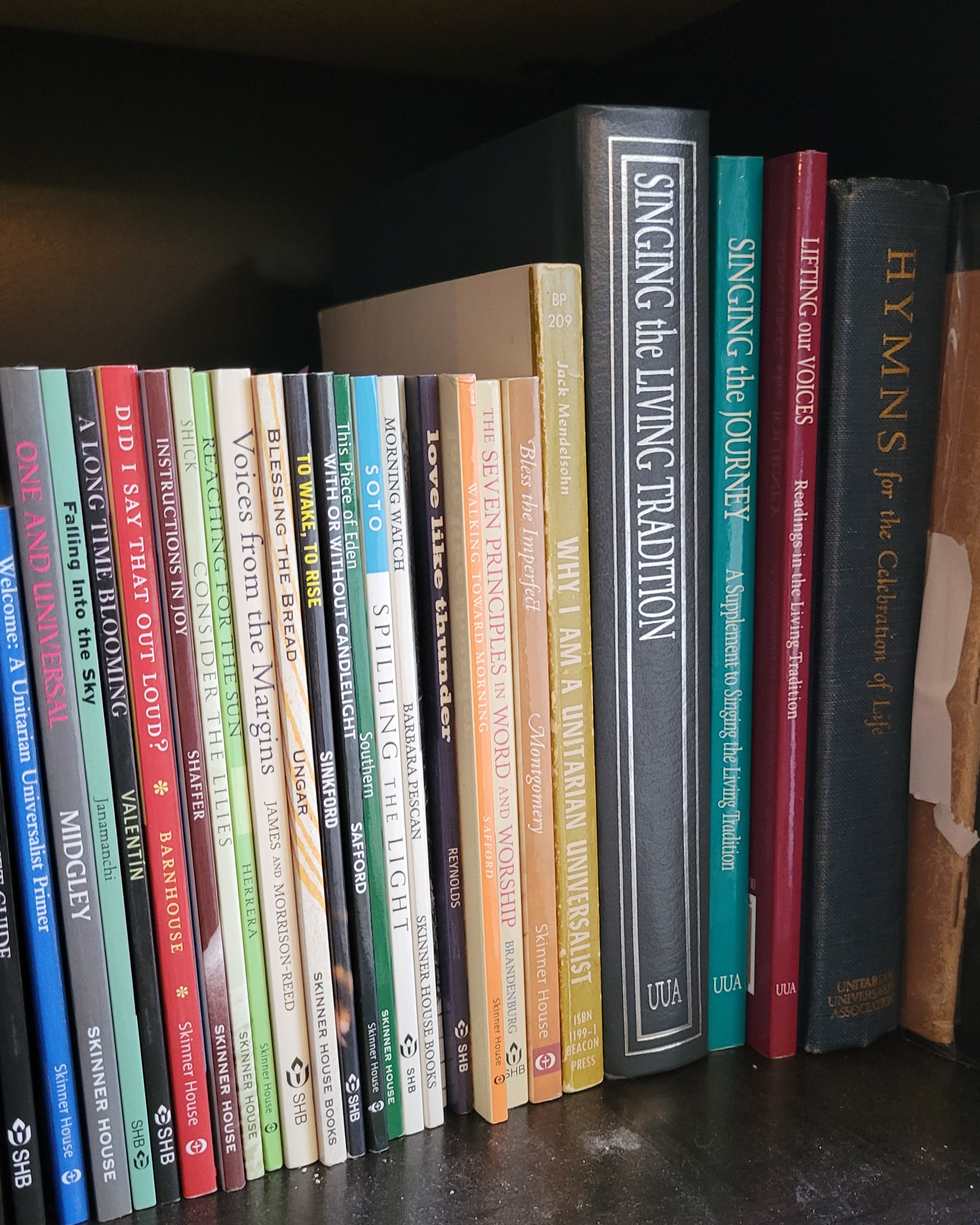 a photograph of the site-author's bookshelf, holding UUA meditation manuals, hymnals, and other worship resources